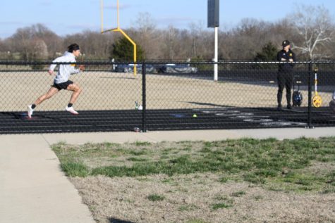 Nick Meza, sophomore, practices his baton handoffs and sprints as Nathan Moser watches his form.