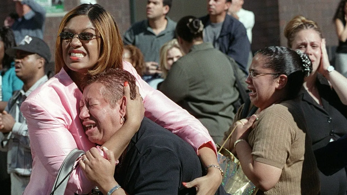 People reflect on 9/11 at a memorial in New York with the skyline in the background