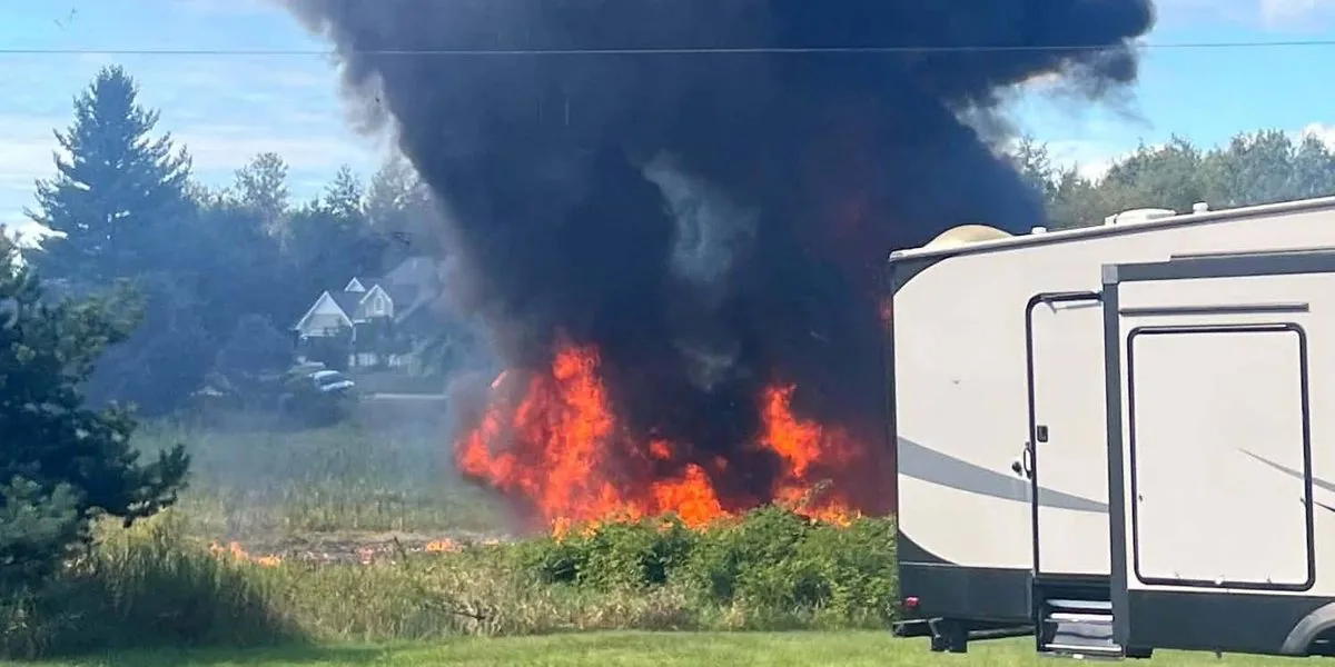 Smoke rises from a rural field after an F-16 fighter jet crashes in northern Michigan