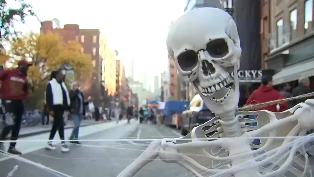 Families gather on a car-free city street for Halloween activities and trick-or-treating